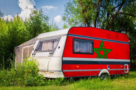 A car trailer, a motor home, painted in the national flag of  Morocco stands parked in a mountainous. The concept of road transport, trade, export and import between countries.の写真素材