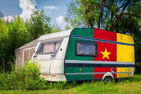 A car trailer, a motor home, painted in the national flag of  Cameroon stands parked in a mountainous. The concept of road transport, trade, export and import between countries.の写真素材