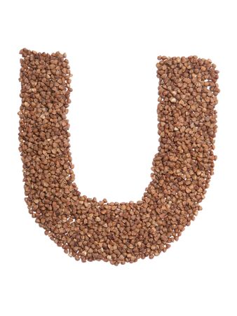 Letter U of the English alphabet from  brown dry buckwheat  on a white isolated background. Food pattern made from groats. Bright alphabet for shops.  Buckwheat for porridgeの写真素材