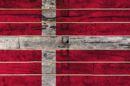 National flag  of  Denmark on a wooden wall background. The concept of national pride and a symbol...