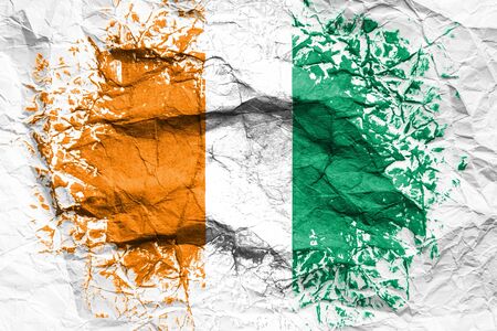 The national flag of the Cote d'ivoire is painted on crumpled paper. Flag printed on the sheet. Flag image for design on flyers, advertising.の写真素材