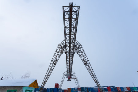 Large metal gantry cranes at a construction site against the blue sky. Type of bearing metal...