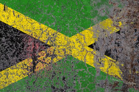 National flag of Jamaica on old peeling wall background.The concept of national pride and symbol of the country.の写真素材