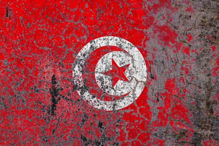 National flag of Tunisia on old peeling wall background.The concept of national pride and symbol of the country.の写真素材