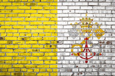 National flag of Vatican  depicting in paint colors on an old brick wall. Flag  banner on brick wall background.の写真素材