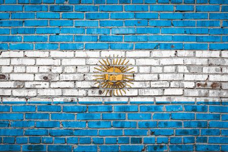 National flag of Argentina  depicting in paint colors on an old brick wall. Flag  banner on brick wall background.の写真素材