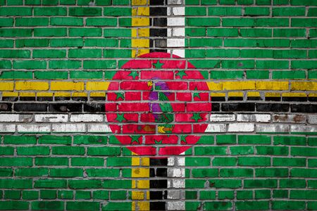 National flag of Dominica
  depicting in paint colors on an old brick wall. Flag  banner on brick wall background.の写真素材
