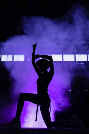Cinematic night portrait of woman in  neo garage , portrait of beautiful woman in  top. Female silhouette on a purple backgroundの写真素材