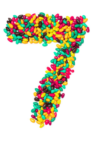 Arabic numeral 7   from multicolored round chocolates on a white isolated background. Food pattern...