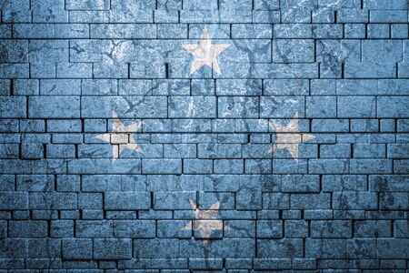 National flag of Federal States of Micronesia on brick  wall background.The concept of national pride and symbol of the country. Flag  banner on  stone texture background.の写真素材