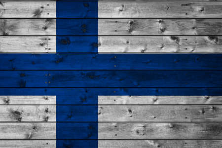 The national flag of Finland is painted on a camp of even boards nailed with a nail. The symbol of the country.の写真素材