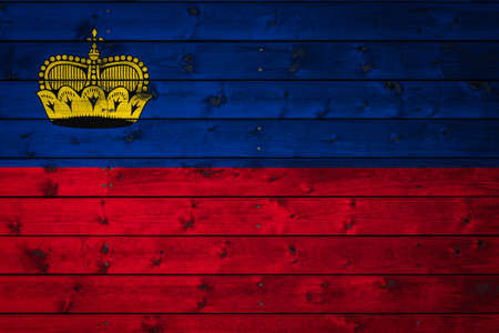 The national flag of Liechtenstein is painted on a camp of even boards nailed with a nail. The symbol of the country.の写真素材