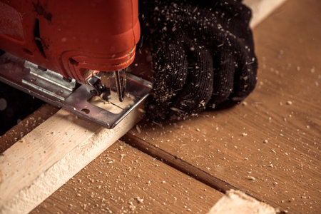 Close up of experienced carpenter in work clothes and small buiness owner carpenter saw and...