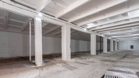 Industrial building interior with white brick walls, concrete floor and empty space for product...