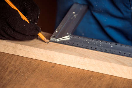 Man drawing line with pencil and holding raw as ruler. House improving, DIY and home decorationの写真素材