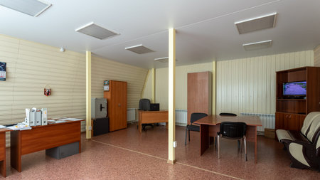 Office with dark wooden tables, wardrobes and chairs for guests