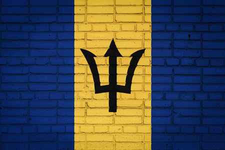 National flag of Barbados depicting in paint colors on an old brick wall. Flag banner on brick wall background.の写真素材