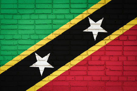 National flag of Saint Kitts and Nevis depicting in paint colors on an old brick wall. Flag banner...