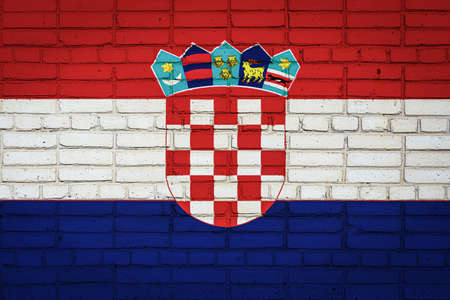 National flag of Croatia depicting in paint colors on an old brick wall. Flag banner on brick wall background.の写真素材
