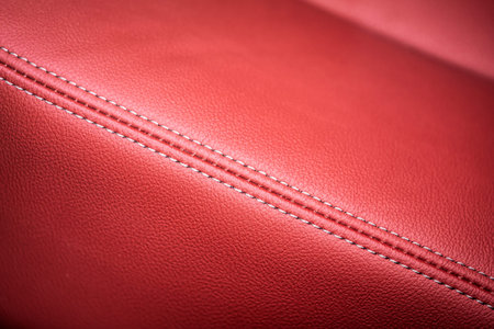 close-up red perforated leather car seat. Skin texture. Close-up corner of driver's seat