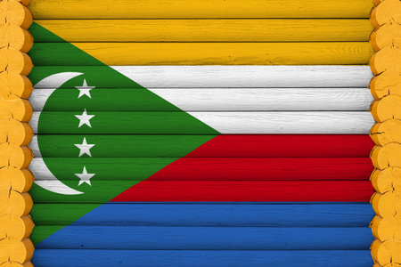 National flag of Comoros on a wooden wall background. The concept of national pride and a symbol of the country. Flags painted on a houseの写真素材