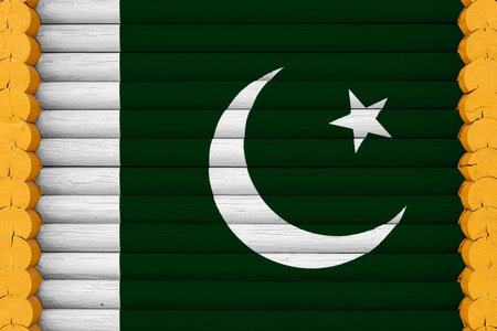 National flag of Pakistan on a wooden wall background. The concept of national pride and a symbol of the country. Flags painted on a houseの写真素材