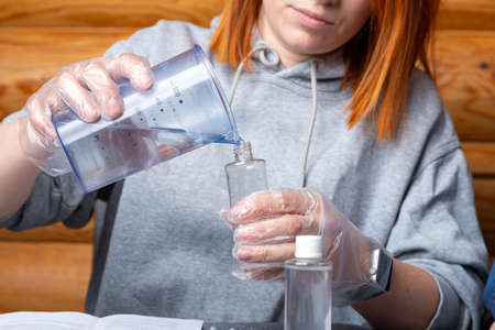 Chemistry education and study concept. Close-up of a woman scientists pour water into a bottle with chemical elements, for experiments at homeの写真素材