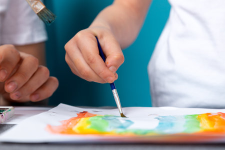 Children's creativity. mom and child son paint watercolor homework for kindergarten on blue backgroundの写真素材