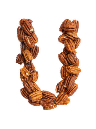 Letter U of the English alphabet from pecans on a white isolated background. Food pattern made from nuts. Bright alphabet for shops.の写真素材