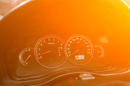 speedometer of a modern car with an integrated fuel gauge in the tank with white arrows under the yellow and orange neon colorの写真素材