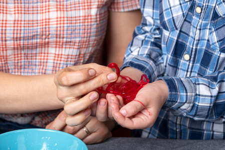 Chemistry education and study concept. close-up mom and her son made a polymer worm with homemade chemical experiments for children. Chemical experiment with polymer wormsの写真素材