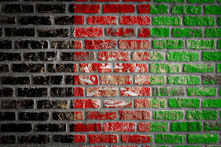 National flag of Afghanistan depicting in paint colors on an old brick wall. Flag banner on brick wall background.の写真素材