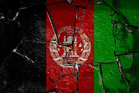 National flag of Afghanistan depicting in paint colors on an old stone wall. Flag banner on broken wall background.の写真素材