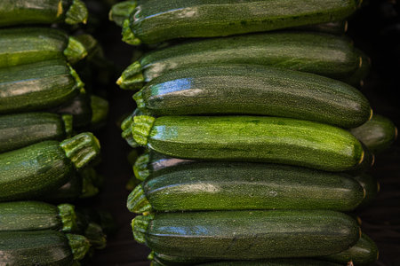 Fresh organic green zucchini on a fresh market, background. Zucchini texture. Lots of organic vegetablesの写真素材