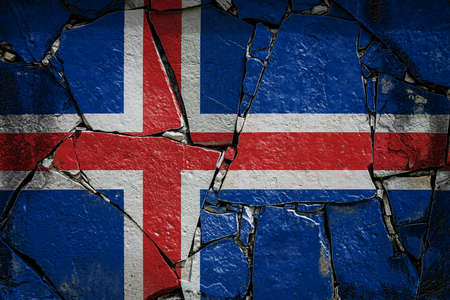 National flag of Iceland depicting in paint colors on an old stone wall. Flag banner on broken wall background.の写真素材