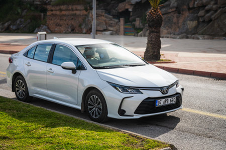 Alanya, Turkey - April 17 2021: white Toyota Corolla is parked on the street on a warm summer day against the backdrop of a buildung, street, shopsのeditorial素材
