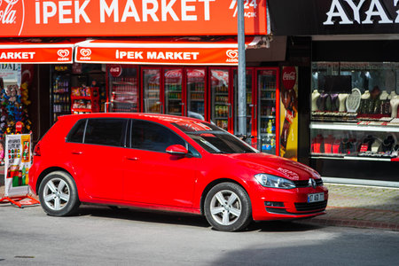Alanya, Turkey - April 17 2021: red Volkswagen Golf is parked on the street on a warm summer day...