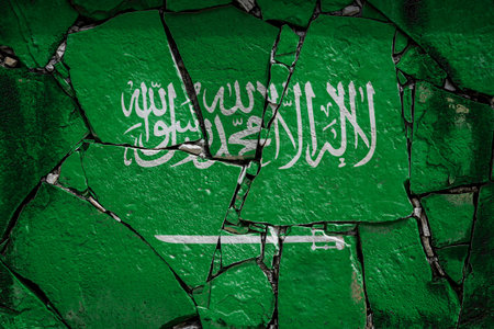 National flag of Saudi Arabia depicting in paint colors on an old stone wall. Flag banner on broken...