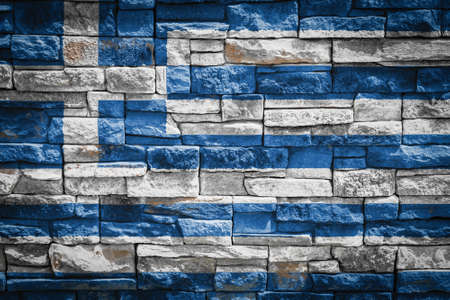 National flag of Greece on stone wall background. The concept of national pride and symbol of the country. Flag banner on stone texture background.の写真素材