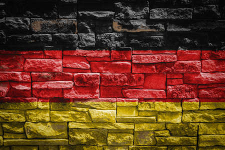 National flag of Germany on stone wall background. The concept of national pride and symbol of the country. Flag banner on stone texture background.の写真素材