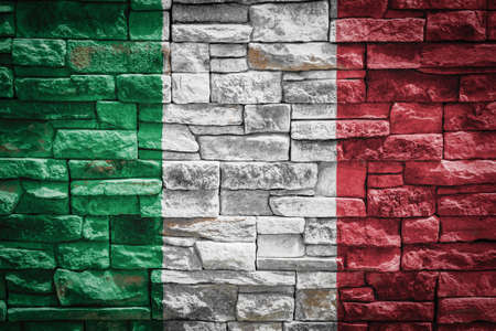 National flag of Italy on stone wall background. The concept of national pride and symbol of the country. Flag banner on stone texture background.の写真素材