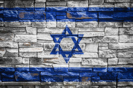 National flag of Israel on stone wall background. The concept of national pride and symbol of the country. Flag banner on stone texture background.の写真素材