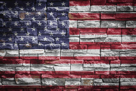National flag of USA on stone wall background. The concept of national pride and symbol of the country. Flag banner on stone texture background.の写真素材