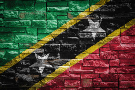 National flag of Saint Kitts and Nevis on stone wall background The concept of national pride and symbol of the country. Flag banner on stone texture background.の写真素材