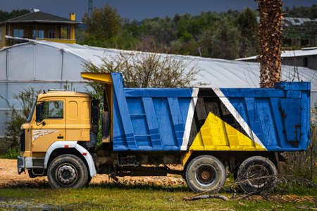 Dump truck with the image of the national flag of Saint Lucia is parked against the background of the countryside. The concept of export-import, transportation, national delivery of goodsの写真素材