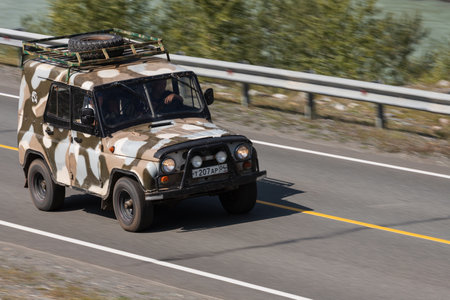 Novosibirsk, Russia - August 08, 2021: UAZ Patriot driving fast on freeway in highlands on summer day on background forestのeditorial素材