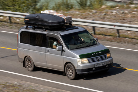 Novosibirsk, Russia - August 08, 2021: silver Honda Stepwgn driving fast on freeway in highlands on...