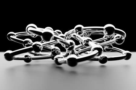 3d illustration of close-up of steel chain links bent in a fancy shape on a black backgroundの写真素材
