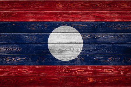 The national flag of Laos is painted on a camp of even boards nailed with a nail. The symbol of the...