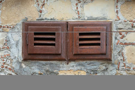 Close-up brown wooden vintage window in an old stone house